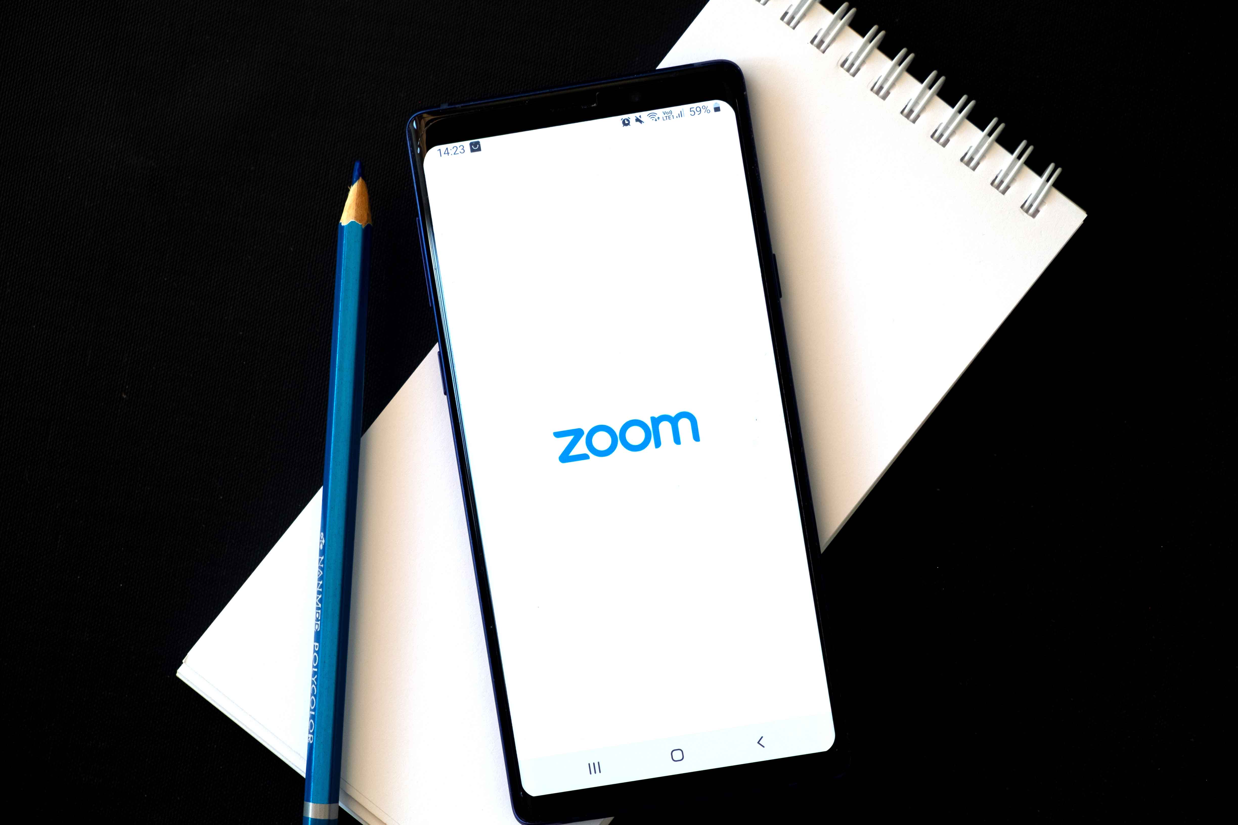 flat-lay-image-of-a-smartphone-with-zoom-icon-on-screen-isolated-on-black-zoom-is-one-of-the-popular_t20_pLK21j